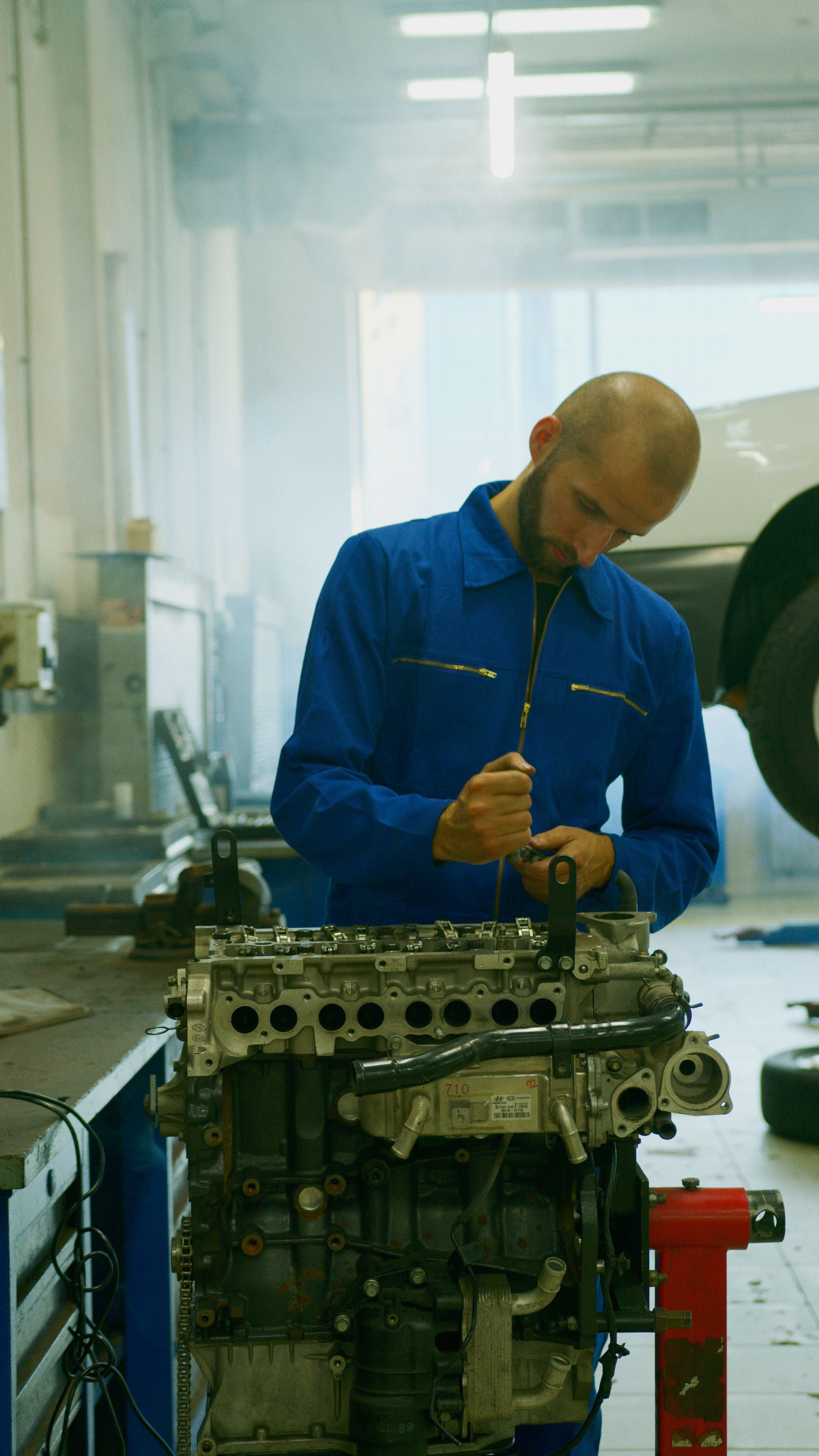 KFZ-Mechaniker bei Arbeiten an einem Motor in der Werkstatt